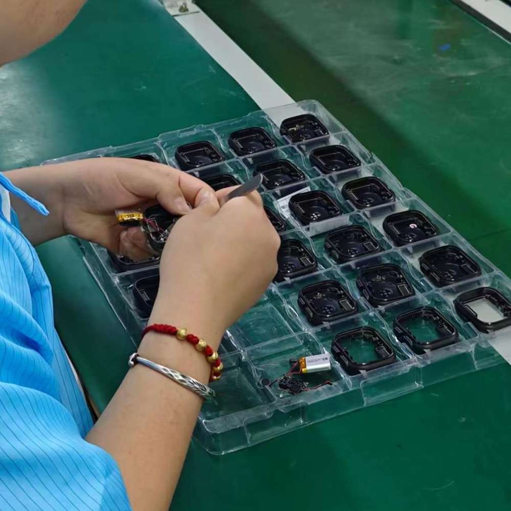 Watch cases being assembled by hand at a factory workbench